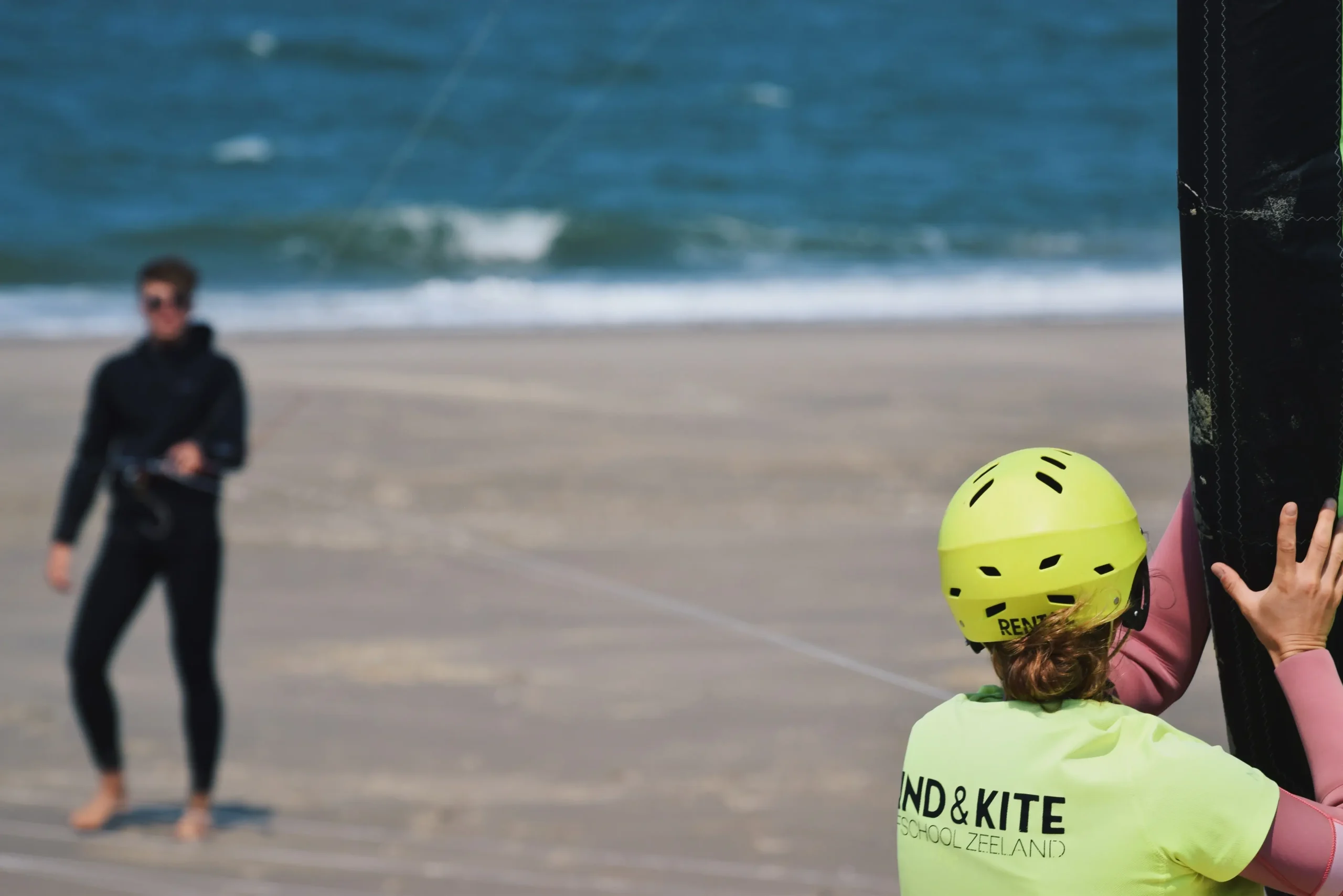 Wijzende kitesurf studenten en instructeur
