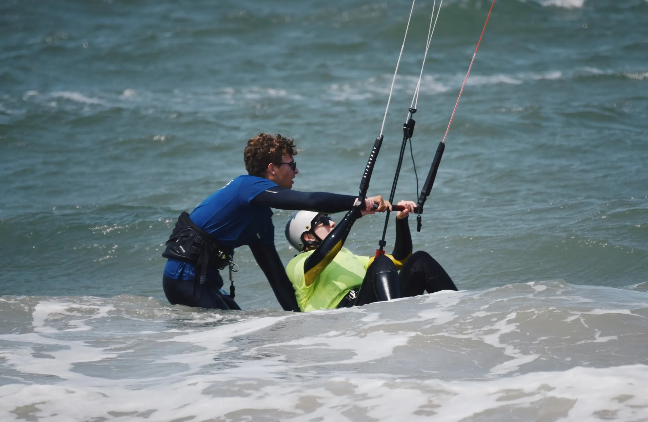 Wijzende kitesurf studenten en instructeur